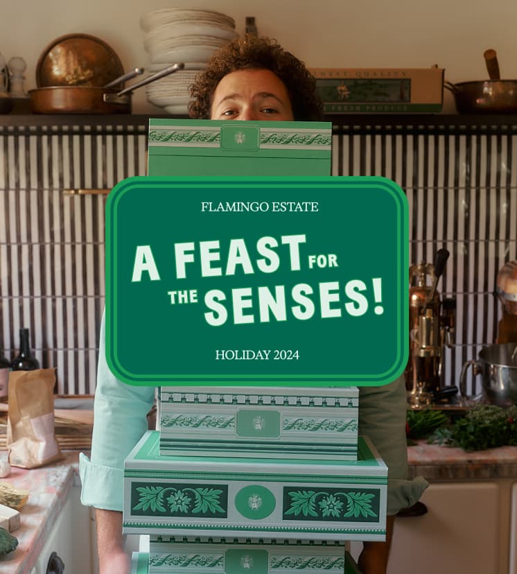 A person partially obscured by a stack of green boxes stands in a kitchen.