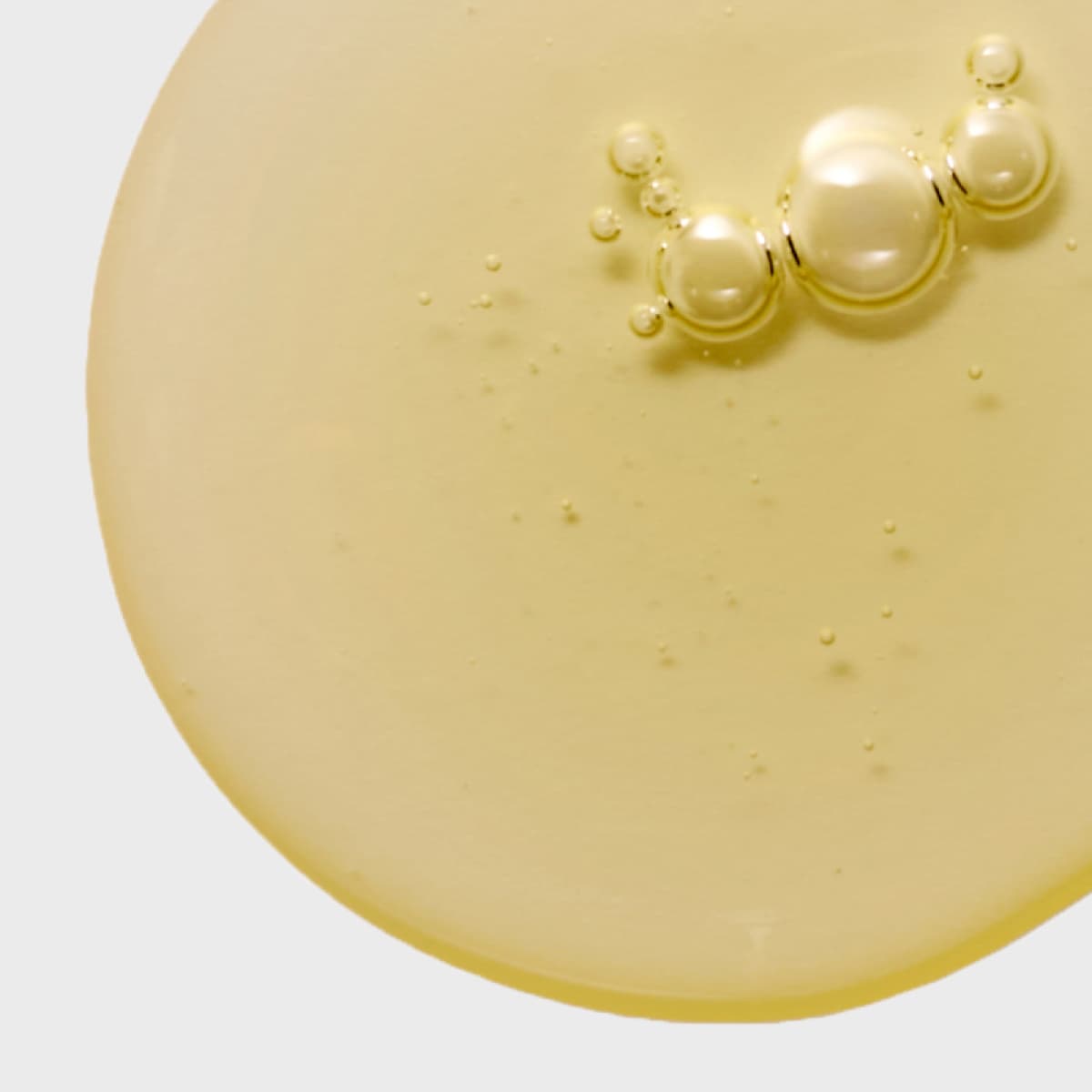 Yellow liquid forms bubbles on a flat surface.