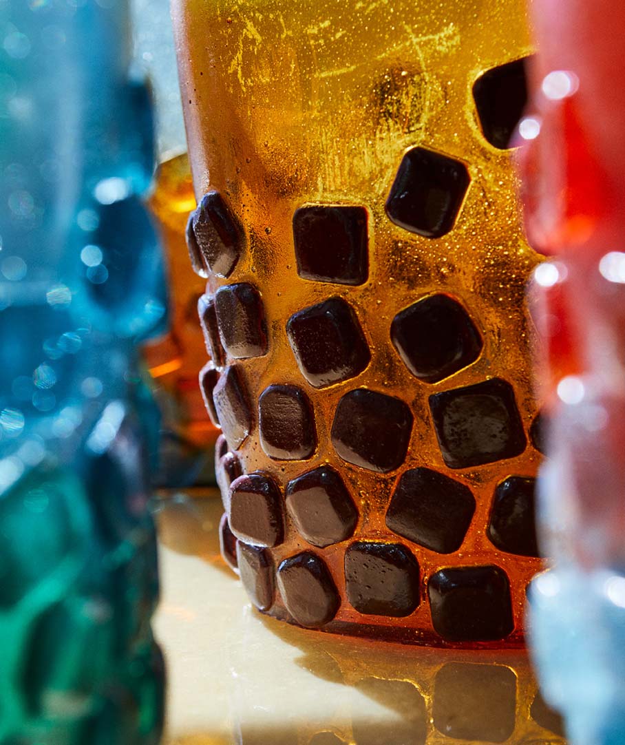 Glass with orange and black square patterns reflecting light.